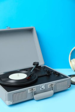 Mavi masada vinil diski olan bir kayıt oynatıcı