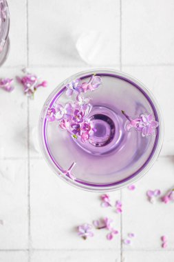 Açık fayanslı leylak çiçekli bir bardak kokteyl.