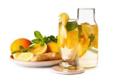 Beyaz arka planda limonlu bir bardak ve bir şişe erimiş su.