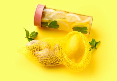 Sarı arka planda limonlu ve naneli spor şişesi.