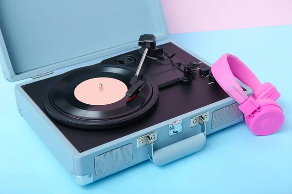 粉红墙壁附近桌子上有带乙烯盘和耳机的唱机 — 图库照片