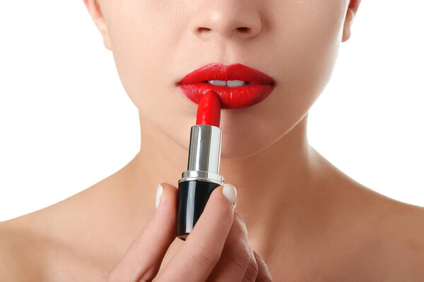Woman applying red lipstick on white background, closeup