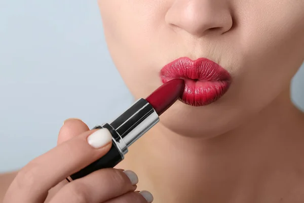 灰色の背景に赤い口紅を適用する女性 クローズアップ — ストック写真