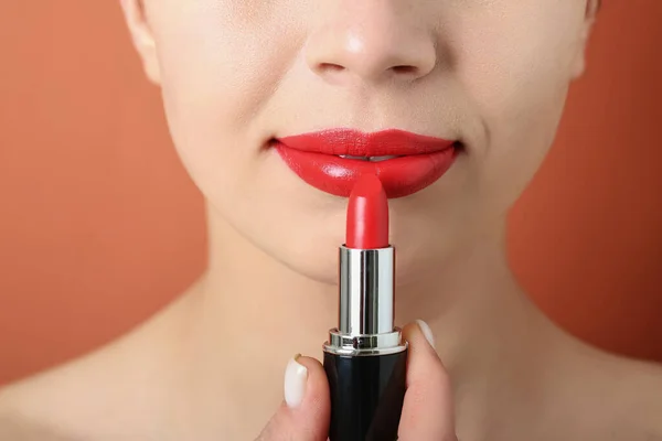 色の背景に赤い口紅を適用する女性 クローズアップ — ストック写真