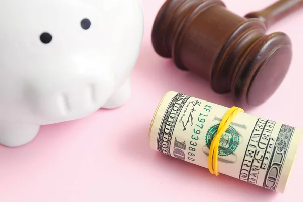 ピンクの背景に裁判官のギャベルとお金を持つ貯金箱 破産概念 — ストック写真