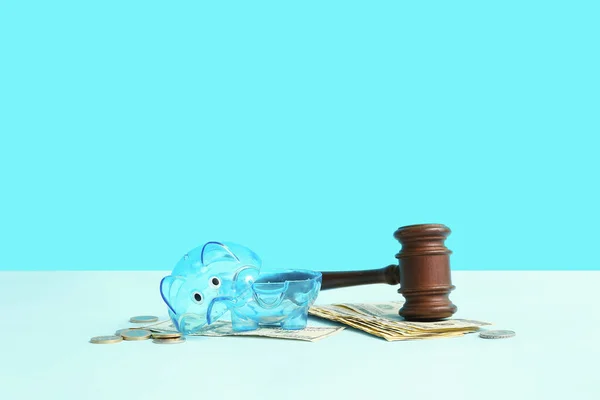 青い背景に裁判官のギャベルとお金を持つ壊れたプラスチック製の貯金箱 破産概念 — ストック写真