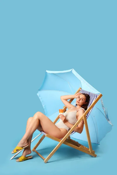 Young Woman Sunscreen Cream Deck Chair Blue Background — Stock Photo, Image
