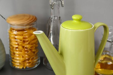 Siyah masanın üzerinde farklı mutfak malzemeleri olan çaydanlık.