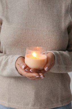 Elinde yanan mum tutan kadın, yakın plan.