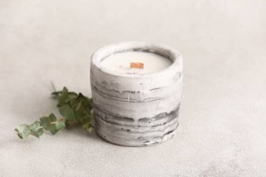 Beyaz zemin üzerinde mum ve okaliptüs bulunan tutucu