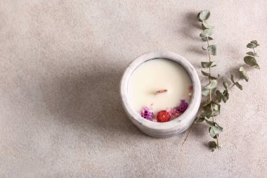 Beyaz zemin üzerinde mum ve okaliptüs bulunan tutucu