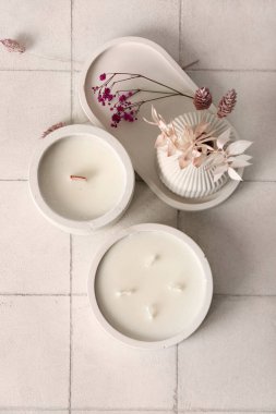 Beyaz karo zemin üzerinde mumları ve sazlığı olan tutucular