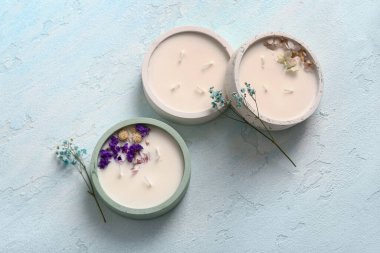 Mavi arka planda mumları ve çiçekleri olan tutucular