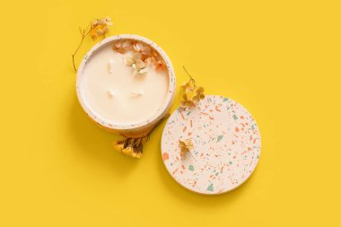 Sarı arka planda mumlu ve çiçekli tutucu