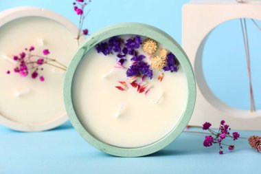 Mavi arka planda mumları ve dekoratif podyumu olan tutucular