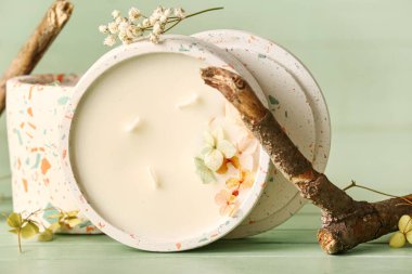 Yeşil ahşap arka planda mumları ve ağaç dalları olan tutucular