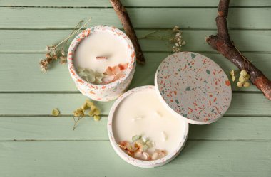 Yeşil ahşap arka planda mumları ve ağaç dalları olan tutucular