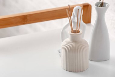 Masada bir şişe sazlık dağıtıcı ve dekor, yakın plan.