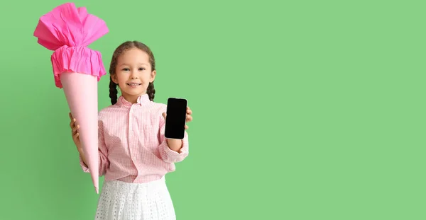可愛いです女の子とともに学校のコーンと携帯電話上の緑の背景とともにスペースのためにテキスト — ストック写真