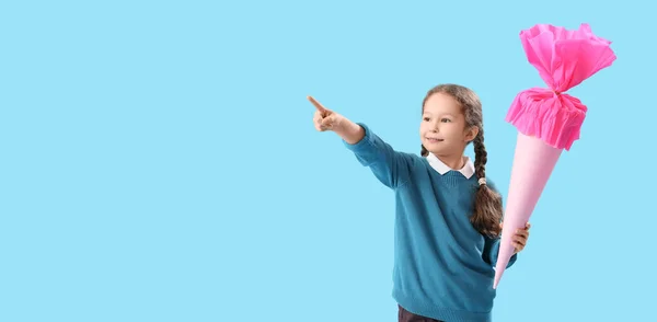 可爱的小女孩 带着上学用的锥形圆锥指着浅蓝色的背景 上面有文字空间 — 图库照片