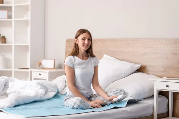 Young Woman Sitting Electric Heating Pad Bedroom — Stock Photo, Image