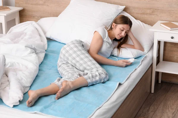 Νεαρή Γυναίκα Ξαπλωμένη Ηλεκτρικό Θερμαινόμενο Μαξιλάρι Στο Υπνοδωμάτιο — Φωτογραφία Αρχείου