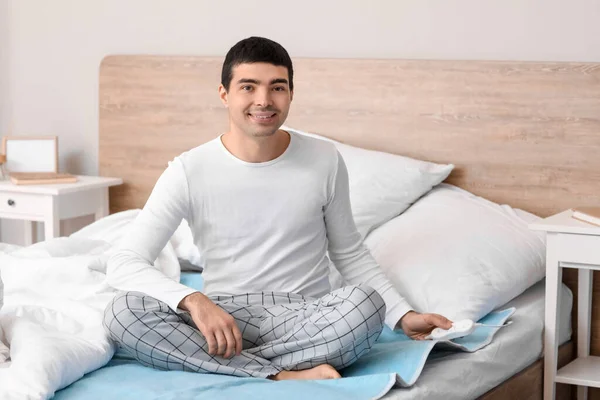 Genç Adam Yatak Odasındaki Elektrikli Isıtma Yastığında Oturuyor — Stok fotoğraf