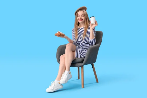 Young Woman Croissant Cup Coffee Sitting Armchair Blue Background — ストック写真