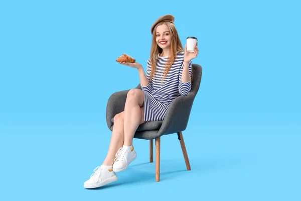Young Woman Croissant Cup Coffee Sitting Armchair Blue Background — ストック写真