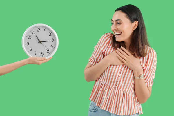 幸せな若いです女性とともに腕時計と壁時計上の緑の背景 — ストック写真