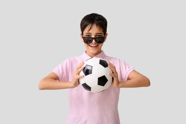 Malý Chlapec Fotbalovým Míčem Nosí Sluneční Brýle Šedém Pozadí — Stock fotografie