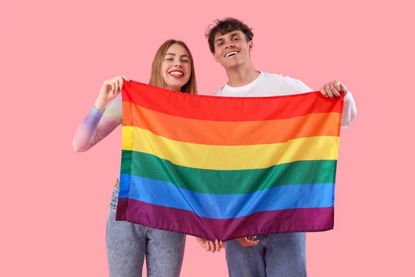 ピンクの背景にLgbtの旗を持つ若いカップル — ストック写真