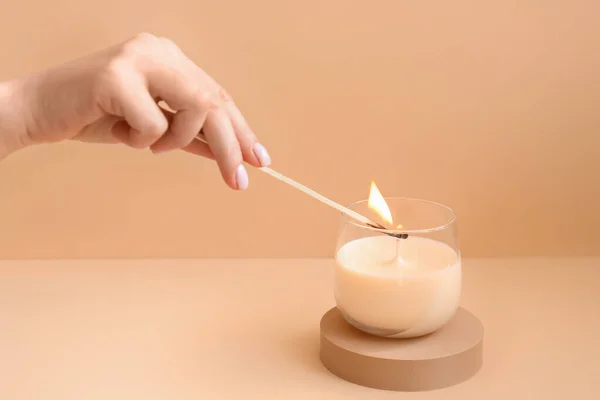 Женщина Зажигает Свечи Бледно Оранжевом Фоне — стоковое фото