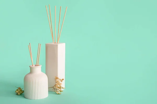 stock image Bottles of reed diffuser and flowers on turquoise background