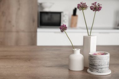 Mutfaktaki masada güzel çiçekler ve mum, yakın plan.