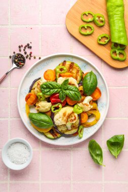 Pembe fayanslı ızgara sebze tabağı.