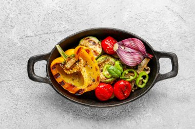 Gri arka planda ızgara sebzeli fırın.