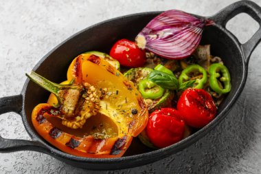 Gri arka planda ızgara sebzeli fırın.