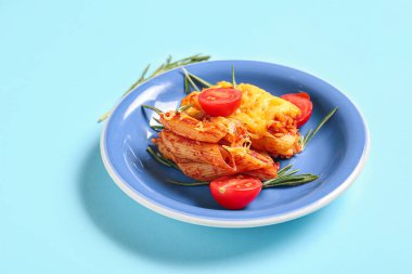 Mavi arka planda domates soslu ve peynirli makarna.
