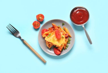 Mavi arka planda domates soslu ve peynirli makarna.