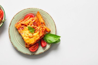 Gri arkaplanda domates soslu ve peynirli makarna.