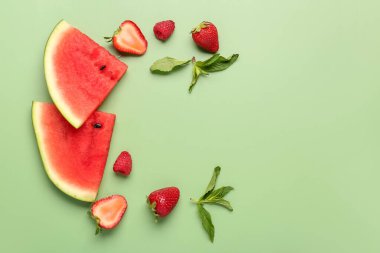 Taze karpuz parçaları ve yeşil arka planda farklı meyveler.