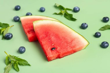 Yeşil arka planda taze karpuz ve yaban mersini parçaları