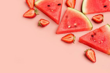Pembe arka planda taze karpuz ve çilek parçaları.