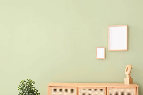 Современный Комод Комодом Чистыми Картинками Висящими Зеленой Стене Комнате — стоковое фото