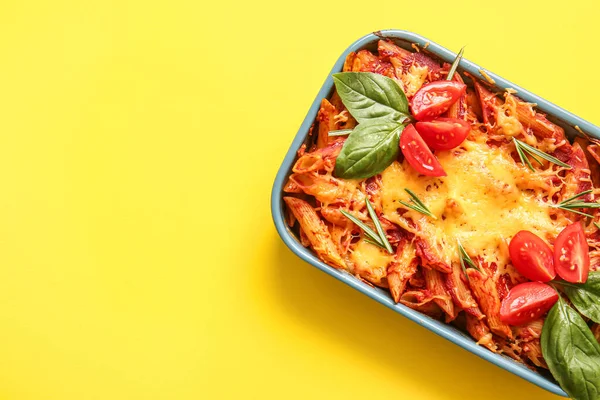 stock image Baking dish of pasta with tomato sauce and cheese on yellow background