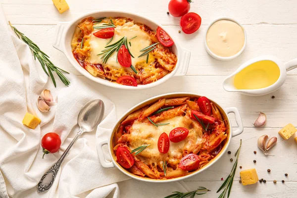 stock image Baking dishes of pasta with tomato sauce and cheese on white tile background