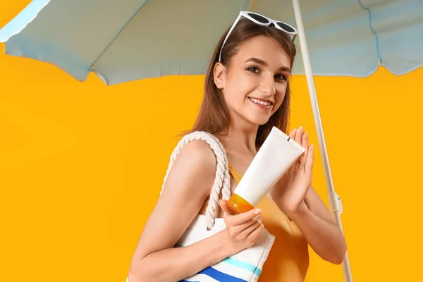 Jonge Vrouw Met Zonnebrandcrème Strandtas Parasol Gele Achtergrond — Stockfoto