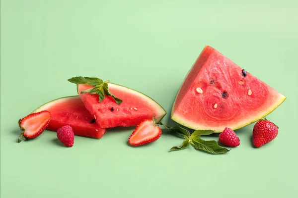 Stücke Von Frischer Wassermelone Und Verschiedenen Beeren Auf Grünem Hintergrund — Stockfoto