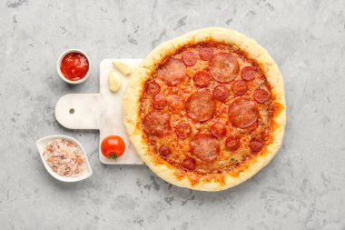 Board with delicious pepperoni pizza on grey grunge background